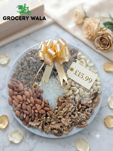 Rakhi special gourmet nut and dried fruit gift tray on a ceramic plate with gold satin ribbon bow — cashews, almonds, walnuts, raisins and sugar crystals, 1.5kg full quantity