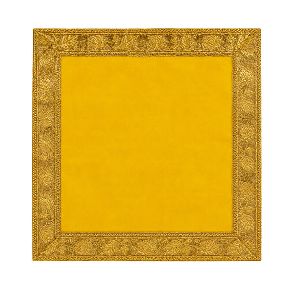 Yellow Pooja velvet cloth with ornate gold border on white background