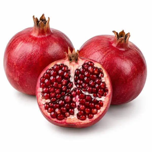 Fresh pomegranates with cut fruit on a white background