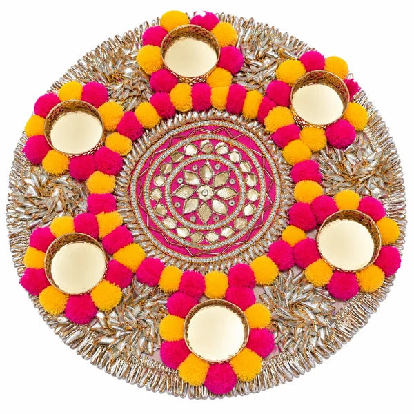 Round pink and yellow pom-pom Rangoli with six gold-tone tealight holders and metallic floral detailing