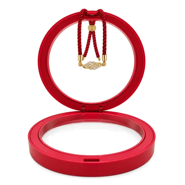 Red Aura Rakhi with gold centrepiece in open red jewellery case