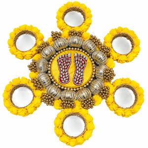 Yellow Lakshmi Charan Rangoli with jewelled red footprints, metallic bead detailing and six floral tealight holders